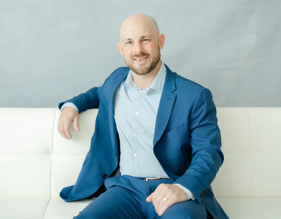 Logan Williamson, LPC, mid-conversation on a white couch
